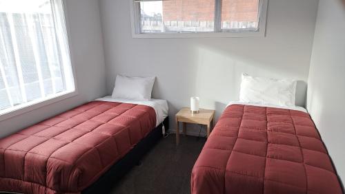 two beds sitting next to each other in a room at South City Accommodation unit 4 in Invercargill