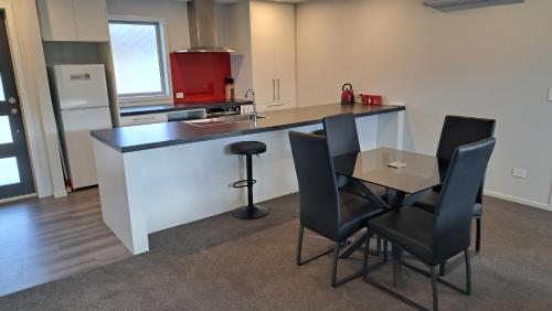 uma cozinha com um balcão, uma mesa e cadeiras em South City Accommodation unit 4 em Invercargill