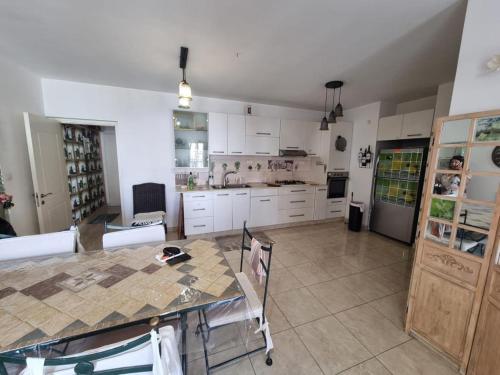 a kitchen with white cabinets and a table with chairs at Charming Warm and Sun-Filled 1 and 2 Bedroom Apartment in Ashdod