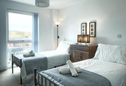 ein Hotelzimmer mit 2 Betten und einem Fenster in der Unterkunft Elegant and Bright Seaside APT in Swansea Marina in Swansea