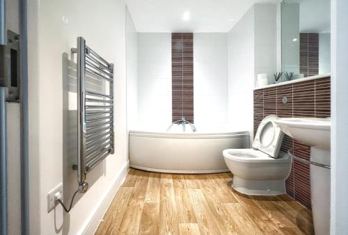 ein Badezimmer mit einem WC, einem Waschbecken und einer Badewanne in der Unterkunft Elegant and Bright Seaside APT in Swansea Marina in Swansea