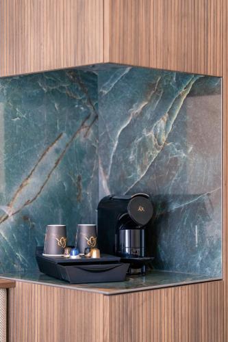 a counter with two cups and a coffee maker at Hotel Du Parc in Ostend