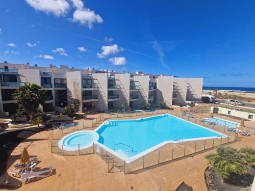 a large swimming pool in front of a building at Ocean View Penthouse El Cotillo in Cotillo