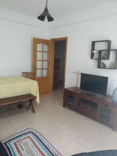 a bedroom with a bed and a flat screen tv at Apartamento em Fuseta - Casa da Praia in Fuzeta