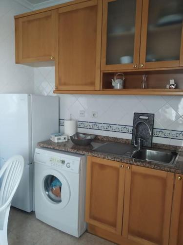 a kitchen with a washing machine and a sink at Apartamento em Fuseta - Casa da Praia in Fuzeta