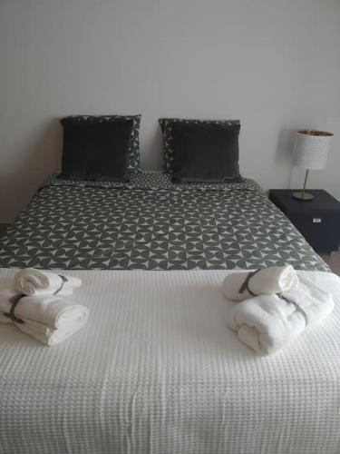 a bedroom with a bed with towels on it at Apartamento em Fuseta - Casa da Praia in Fuzeta