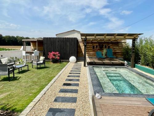 a backyard with a swimming pool and a house at Idyllique Studio PiscineSPA, Sauna au jardin tropical in Jouarre