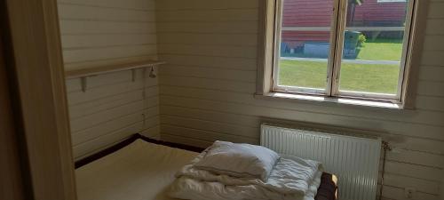 a small room with a bed and a window at Vackert belägen lägenhet i Gesunda in Sollerön