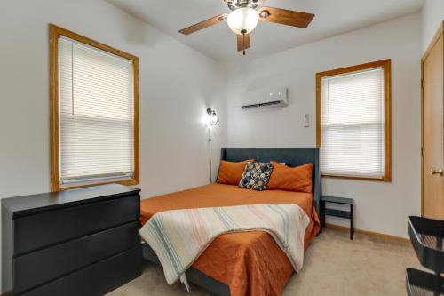 a bedroom with a bed and a dresser and two windows at Cozy Westmont Home Walk to Metra Station! in Westmont