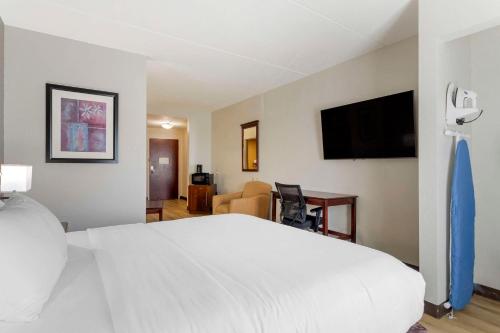 a bedroom with a white bed and a flat screen tv at Comfort Suites Kodak Sevierville in Kodak