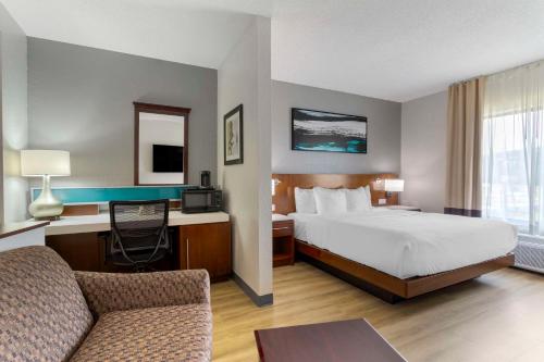 a hotel room with a bed and a desk at Comfort Suites Kodak Sevierville in Kodak