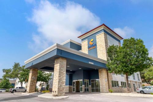 a building with a clock on top of it at Comfort Suites Medical Center near Six Flags in San Antonio