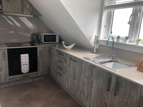 a kitchen with a sink and a microwave at Sea dream lodge -coastal location/sea views/self-contained in Southerndown