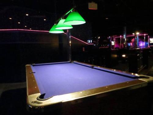 a ping pong table with a green umbrella on it at Filmores Hotel in Toronto
