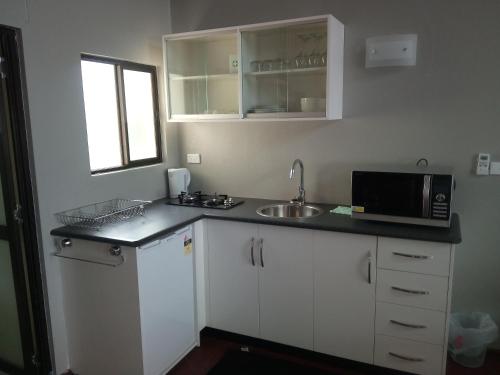 a kitchen with a sink and a microwave at Seaside Villa in Singatoka