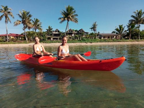twee vrouwen in een rode kajak in het water bij Seaside Villa in Sigatoka