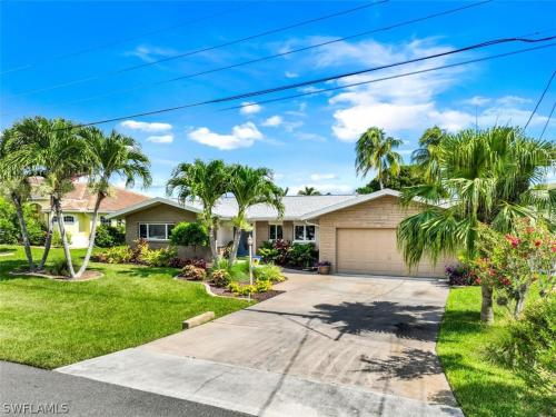 een huis met palmbomen en een oprit bij Good Vibes - Waterfront Living in Cape Coral