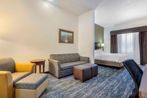 キーストーンにあるComfort Inn & Suites Mt Rushmoreのベッドとリビングルームが備わるホテルルームです。