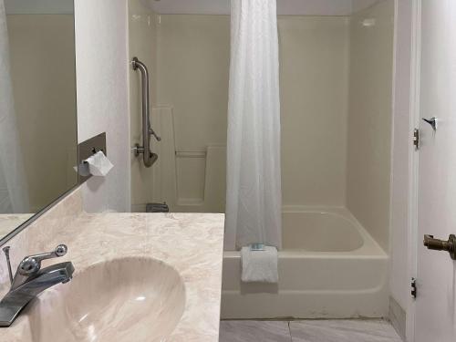 Motel 6 Fancy Gap VA في Fancy Gap: حمام مع حوض وحوض استحمام