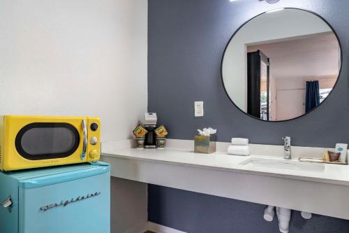 a bathroom with a sink and a tv on a counter at Heights House Hotel, Ascend Hotel Collection in Houston