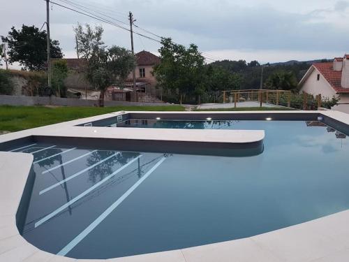a large swimming pool with a blue coating on it at Ecorustics stay - Casa Estêvão in São Pedro do Sul