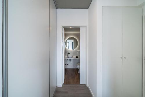 un pasillo que conduce a un baño con paredes blancas en La Vie Suite Palermo Hollywood, en Buenos Aires