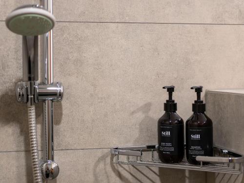 two bottles of soap sitting on a shelf in a bathroom at Wanaka Springs Lodge in Wanaka