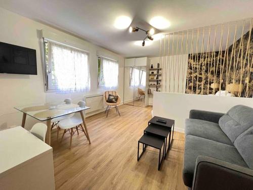 a living room with a couch and a table at Le Belvédère in Orléans