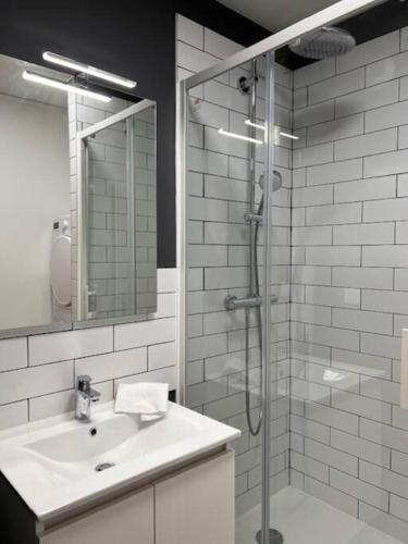 une salle de bain blanche avec une douche et un lavabo dans l'établissement Le Belvédère, à Orléans