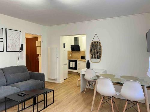 a living room with a couch and a table and chairs at Le Belvédère in Orléans