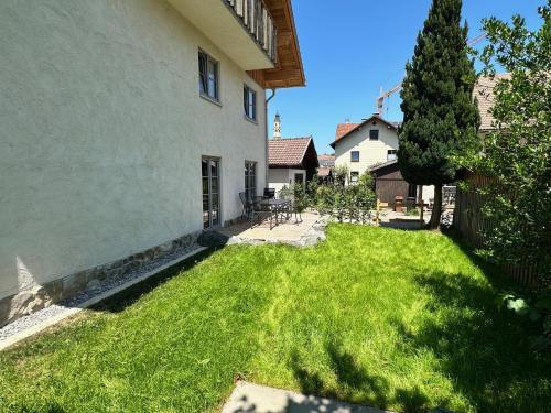a yard with green grass next to a building at Ferienwohnungen WahlHeimat-Pfronten in Pfronten