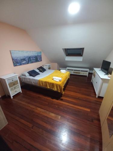 Un dormitorio con una cama con una manta amarilla. en Meda hogar, en Caldas de Reis