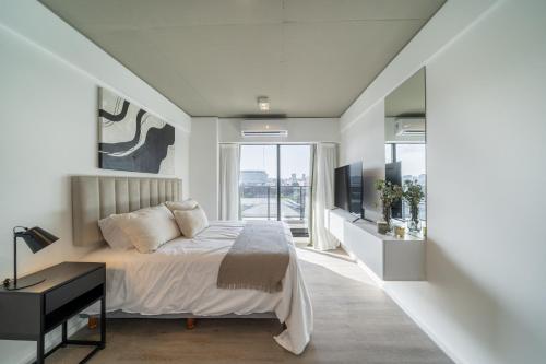 sypialnia z łóżkiem i dużym oknem w obiekcie La Vie Palermo Hollywood w BuenosAires