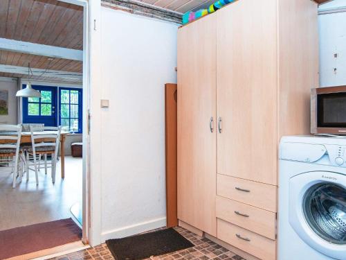 a laundry room with a washer and a microwave at 6 person holiday home in Ørsted-By Traum in Ørsted