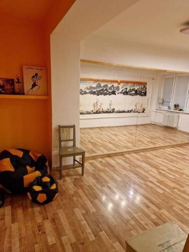 ドゥナイスカー・ストレダにあるMelinda's Dance Space- dance club apartment in Dunajská Stredaの椅子が備わるウッドフロアの空き部屋