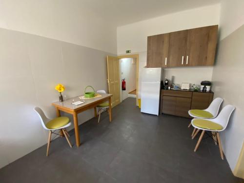 eine Küche mit einem Tisch und Stühlen sowie einem Kühlschrank in der Unterkunft Elvas Casa Sao Francisco in Elvas