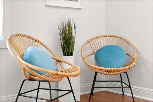 two wicker chairs with blue cushions next to a vase at Crescent Moon Palace - A Luxury Home with Pool, Parking, Just steps to the Beach in Panama City Beach