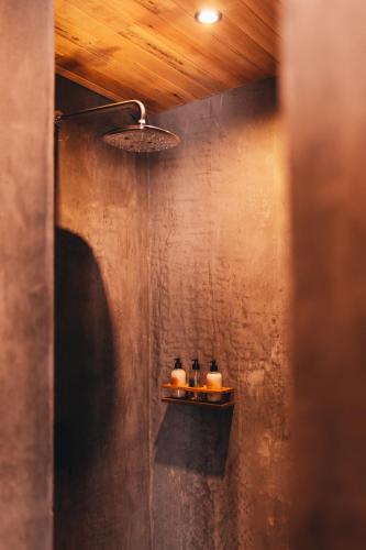 a bathroom with two bottles on a shelf on the wall at Naked Hotel Zipolite -Adults Only- in Zipolite