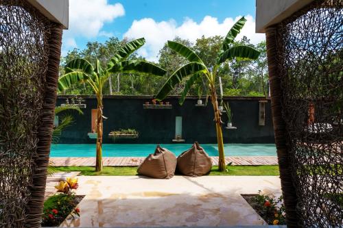 uma vista através do portão de uma casa com piscina em Xamira Tulum Luxury Condo em Tulum