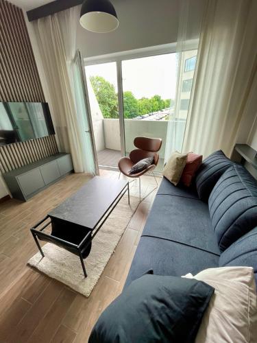 弗次瓦夫的住宿－Studio z balkonem. Słonimskiego 2，客厅配有蓝色的沙发和桌子