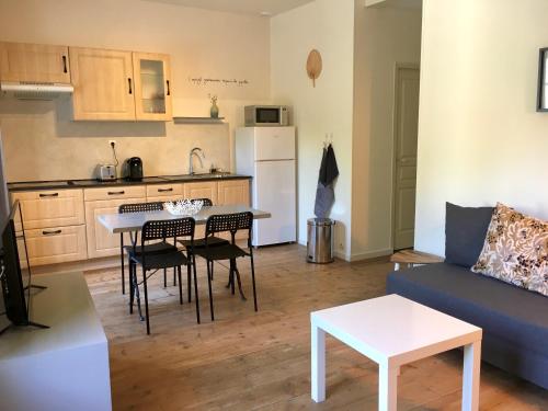 un salon avec un canapé et une table et une cuisine dans l'établissement Villa Elda, à Saint-Jean-dʼAngély