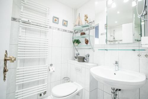 een witte badkamer met een wastafel en een toilet bij Sylt-to-hus-Alt-Westerland in Westerland