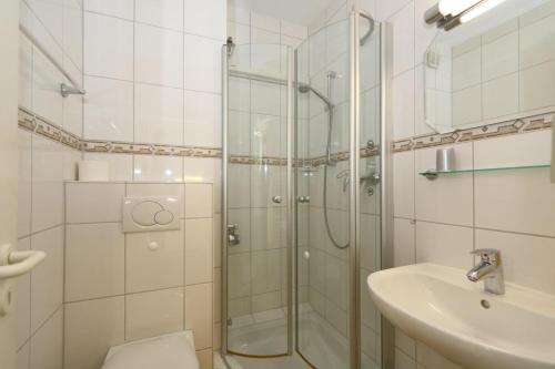 ein Bad mit einer Dusche und einem Waschbecken in der Unterkunft App. Rüter 57 in Westerland
