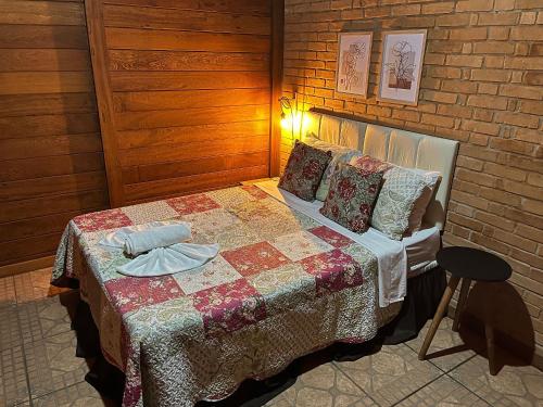 une chambre avec un lit avec une couette dessus dans l'établissement Chalés Belo Vale - Rua do Curro, à Conceição da Ibitipoca