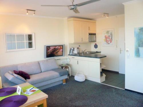 Una sala de estar con un sofá y una cocina. en App-Grimme-09-O, en Westerland