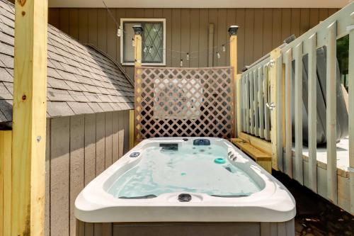 a hot tub on the deck of a house at Cozy Gouldsboro Home with Fire Pit in Big Bass Lake! in Gouldsboro