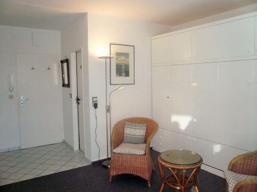 Zimmer mit einem Stuhl, einem Tisch und einer Lampe in der Unterkunft Sievers 37 in Westerland