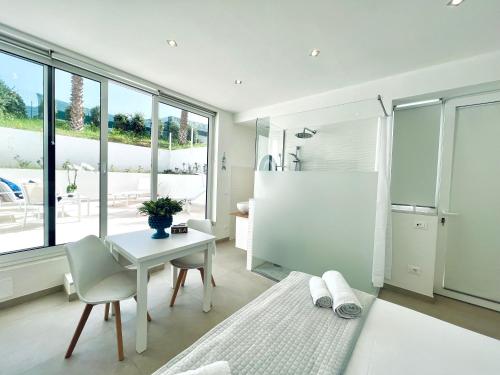 a bedroom with a desk and a table and a bathroom at Torre Pozzillo Beach in Cinisi
