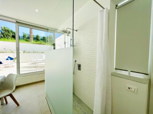 a bathroom with a shower and a glass door at Torre Pozzillo Beach in Cinisi
