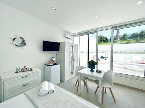 a bedroom with a bed and a table and chairs at Torre Pozzillo Beach in Cinisi